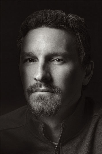 Greyscale image of manwith goatee staring off